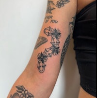 a woman's arm with a black and white flower tattoo
