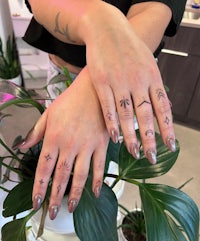 a woman's hands with tattoos on them