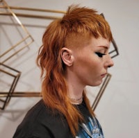 a woman with red hair and a shaved head