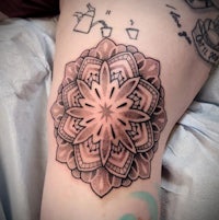 a woman's thigh with a mandala tattoo